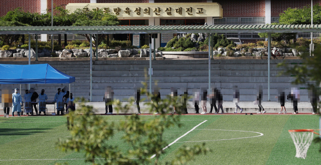 지난 7일 오후 서울 노원구 대진고등학교 운동장에 설치된 선별진료소에서 신종 코로나바이러스 감염증(코로나19) 검사를 받기 위해 학생들이 줄을 서고 있다. 연합뉴스