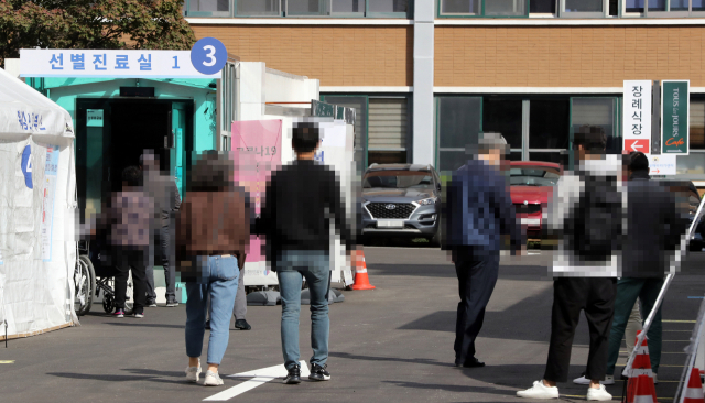 15일 서울 동대문구 국립중앙의료원 코로나19 선별진료소에 검사를 받으려는 시민 등이 대기하고 있다. 연합뉴스