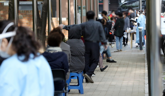 지난 22일 서울 관악구보건소에서 코로나19 검사를 받으려는 시민들이 거리두기를 하며 검사를 기다리고 있다. 연합뉴스