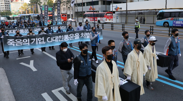 택배노동자 과로사 대책위원회가 17일 오후 을지로입구에서 CJ대한통운 규탄대회 후 올해 사망한 택배노동자 5명의 영정을 들고 추모행진을 하고 있다. 택배 배송 중 사망한 고 김원종 씨 유가족과 시민사회단체 대표 등이 참석했다. 연합뉴스