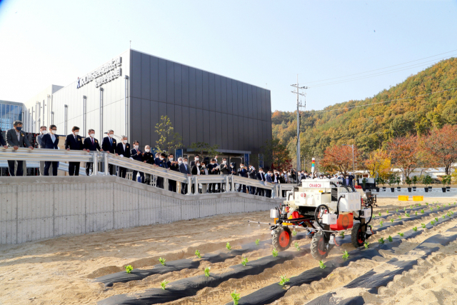 27일 경북 안동에서 문을 연 농업로봇실증센터에서 내빈들이 자동으로 농약을 살포하는 방제로봇 시연을 보고 있다. 안동시 제공