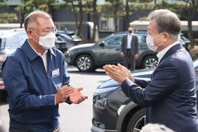 문재인 대통령이 30일 오전 현대자동차 울산공장을 방문, 친환경 미래차 관련 설명을 들은 뒤 정의선 현대차그룹 회장에게 박수를 보내고 있다. 문 대통령의 이번 미래차 생산 현장 방문은 일곱 번째 한국판 뉴딜 현장 행보다. 연합뉴스