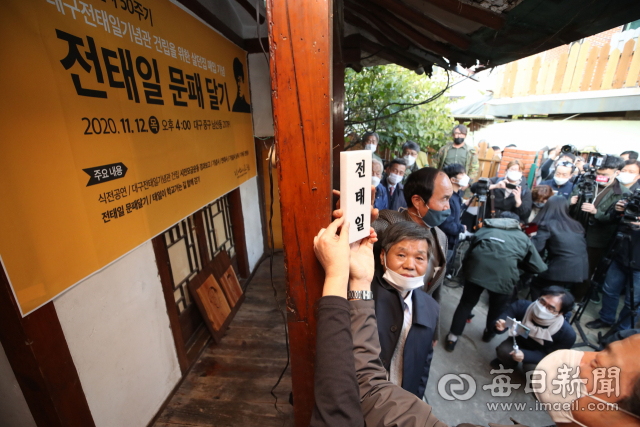 12일 오후 대구 중구 남산동 고(故) 전태일 열사의 옛집에서 유족 등이 문패를 달고 있다. 전 열사가 살았던 이 집은 사단법인 