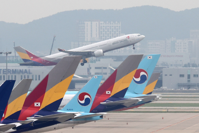 국내 1위 국적항공사 대한항공이 아시아나항공 인수를 검토 중인 것으로 알려지면서 세계 10위권의 초대형 항공사가 탄생할 지 초미의 관심사다. 사진은 인천국제공항에서 대한항공 위로 아시아나 항공기가 이륙하고 있는 모습. 연합뉴스