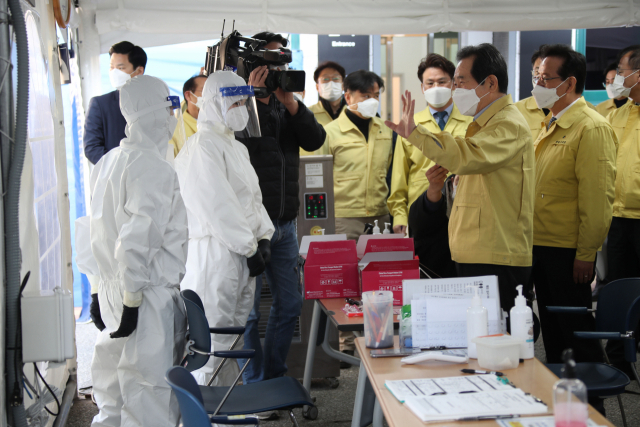 정세균 국무총리가 21일 코로나19 방역현장 점검차 서울 강남구 보건소를 방문해 선별진료소에서 근무중인 방역 관계자들을 격려하고 있다. 연합뉴스