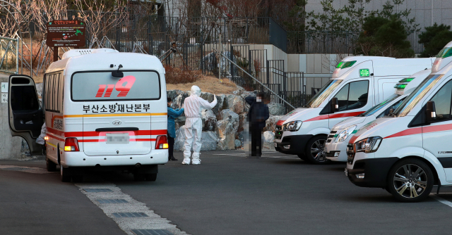 30일 오후 부산 한 고등학교에서 코로나19 확진자 20여명이 대구 동산병원으로 이송되고 있다. 최근 부산지역의 확진자 급증으로 부산 지역 병원 병상이 부족해지자 방역당국이 확진자 일부를 대구로 이송했다. 연합뉴스