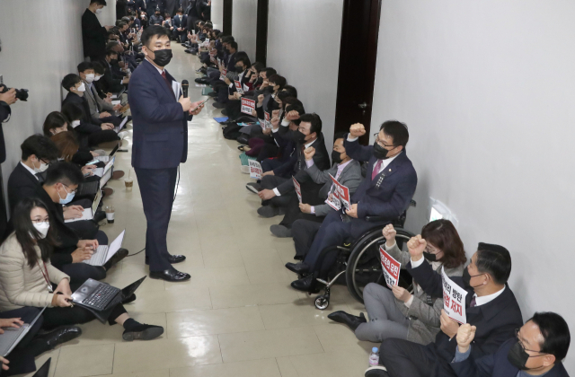 더불어민주당의 공수처법 개정안 강행처리에 항의하는 국민의힘 의원들이 7일 오후 법사위 법안심사1소위가 열리고 있는 국회 법제사법위원회 회의실 앞에서 연좌하고 있다. 연합뉴스