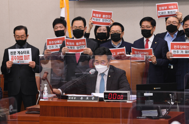 8일 국회 법제사법위원회 전체회의에서 국민의힘 주호영 원내대표와 의원들이 거세게 항의하는 가운데 윤호중 법사위원장이 상법 일부 개정법률안을 가결하고 있다. 연합뉴스