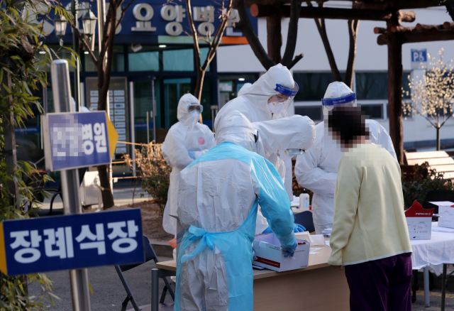 14일 오후 부산 인창요양병원에 마련된 신종 코로나바이러스 감염증(코로나19) 임시선별검사소에서 직원이 문진표를 작성하고 있다. 연합뉴스