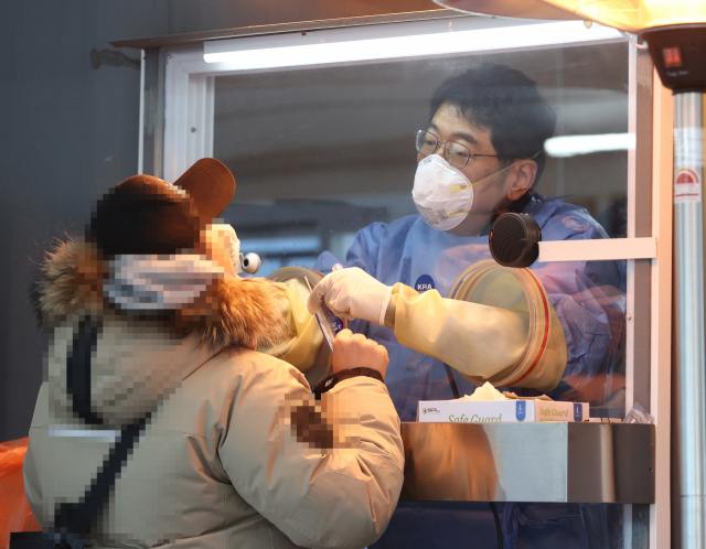 휴일인 19일 오전 서울 중구 시청 앞 서울광장에 마련된 임시 선별진료소에서 의료진이 검체를 채취하고 있다. 이날 국내 신종 코로나바이러스 감염증 신규 확진자 1053명이 발생했다. 연합뉴스