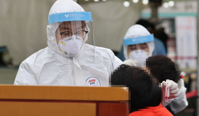 17일 오전 서울역 광장에 설치된 중구 임시 선별검사소에서 의료진이 검체를 채취하고 있다. 중앙방역대책본부는 18일 0시 기준으로 코로나19 신규 확진자가 1천62명 늘어 누적 4만7천515명이라고 밝혔다. 연합뉴스