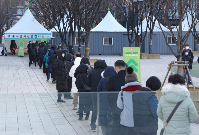 휴일인 19일 오전 서울 중구 시청 앞 서울광장에 마련된 임시 선별진료소에서 시민들이 검사를 받기 위해 줄을 서 있다. 이날 국내 신종 코로나바이러스 감염증 신규 확진자 1053명이 발생했다. 연합뉴스