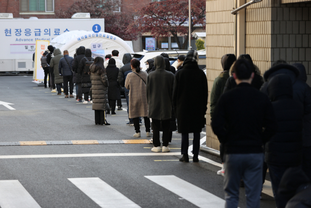 신종 코로나바이러스 감염증(코로나19) 신규 확진자가 1천200명대를 기록한 25일 오전 서울 중구 국립중앙의료원에 마련된 해외출국선별진료소에 시민 및 외국인들이 검사를 받기 위해 줄을 서 있다. 연합뉴스