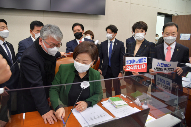 진선미 국회 국토교통위원장이 28일 국회에서 열린 국토교통위원회 전체회의에서 변창흠 국토교통부 장관 후보자의 인사청문경과보고서 채택의 건을 가결한 뒤 자리에서 일어나고 있다. 국민의힘 의원들이 주변에서 항의 시위를 하고 있다. 연합뉴스