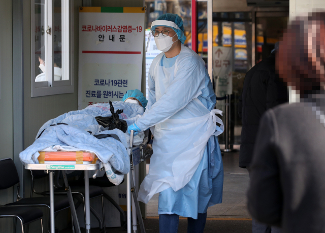 29일 광주 동구 전남대학교병원 선별진료소에서 의료진이 타병원에서 온 한 환자를 신종 코로나바이러스 감염증(코로나19) 검체 채취를 위해 이송하고 있다. 연합뉴스