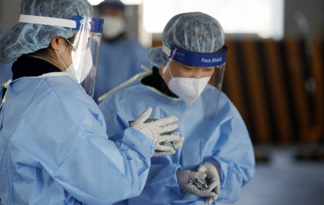 6일 오후 광주 북구선별진료소에서 의료진들이 겨울 한파를 핫팩의 온기로 견디고 있다. 연합뉴스