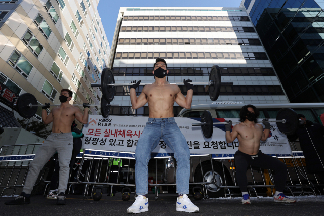 대한민국 기능성 피트니스 협회 회원들이 8일 오후 서울 영등포구 더불어민주당 당사 앞에서 신종 코로나바이러스 감염증(코로나19) 방역대책 관련 모든 실내체육시설에 형평성 있는 조치를 촉구하는 퍼포먼스를 하고 있다. 연합뉴스