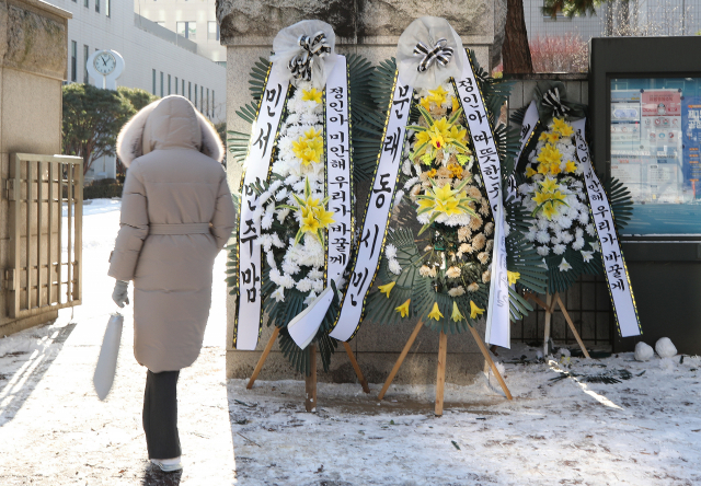 입양한 양부모의 학대로 세상을 뜬 16개월 영아 정인 양 사건에 대한 시민들의 공분으로 뒤늦은 대책이 나오고 있는 7일 오후 정인 양 양부모의 학대치사 사건에 대한 공판이 진행될 서울 양천구 서울남부지방법원 입구에 시민들이 놓아둔 근조 화환이 한파 속 놓여 있다. 연합뉴스