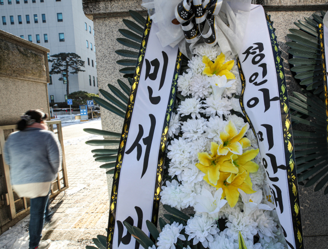 입양한 양부모의 학대로 세상을 뜬 16개월 영아 정인 양 사건에 대한 시민들의 공분으로 뒤늦은 대책이 나오고 있는 7일 오후 정인 양 양부모의 학대치사 사건에 대한 공판이 진행될 서울 양천구 서울남부지방법원 입구에 시민들이 놓아둔 근조 화환이 한파 속 놓여 있다. 연합뉴스