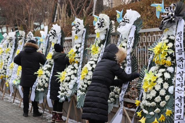 대한아동학대방지협회관계자들이 11일 오전 서울 양천구 남부지방검찰청과 남부지방법원 앞에 정인이 양부모에 대한 엄벌을 촉구하며 근조화환과 바람개비를 설치하고 있다. 법원은 13일 아동학대처벌법 위반(아동학대치사) 등 혐의로 구속기소된 양모 장모씨와 아동복지법 위반 등 혐의를 받는 양부 안모씨의 첫 공판을 연다. 연합뉴스