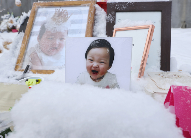 13일 오전 경기도 양평군 하이패밀리 안데르센 공원묘원에 양부모의 학대로 생후 16개월 만에 숨진 정인 양의 사진이 놓여있다. 서울남부지법 형사13부는 이날 아동학대범죄의처벌등에관한특례법 위반 등 혐의로 구속기소 된 양모 장 모 씨의 첫 공판을 연다. 연합뉴스