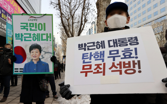 박근혜 전 대통령의 재상고심 선고 공판이 열린 14일 오전 서울 서초역 인근에서 박 전 대통령 지지자들이 손팻말을 들고 있다. 대법원은 이날 특정범죄 가중처벌법상 뇌물 등 혐의로 기소된 박 전 대통령의 재상고심에서 징역 20년·벌금 180억원을 선고한 원심을 확정했다. 연합뉴스