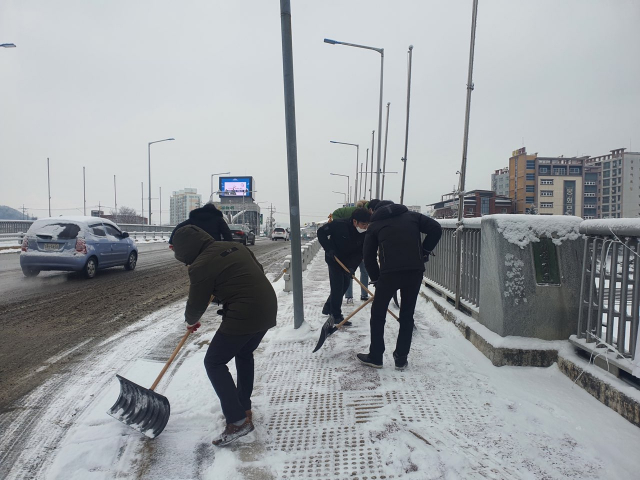 봉화군청 직원들이 시가지 도로변 인도에서 제설 작업을 하고 있다. 봉화군 제공