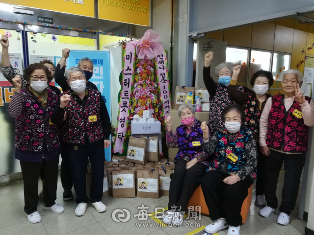 가수 영탁이 22일 경기도 고양시 일산서구 한 노인유치원에 비대면으로 전달한 선물 앞에서 어르신들이 기념촬영을 하고 있다. 노인유치원 제공