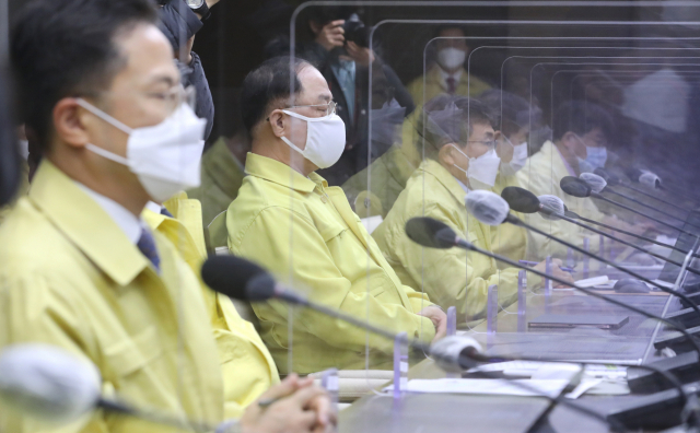 홍남기 경제 부총리 겸 기획재정부 장관(왼쪽 두번째)을 비롯한 각 부처 중대본 참석자들이 26일 오전 세종시 정부세종청사에서 정세균 국무총리 주재로 열린 신종 코로나바이러스 감염증(코로나19) 대응 중앙재난안전대책본부 회의에서 정세균 국무총리의 발언을 경청하고 있다. 연합뉴스