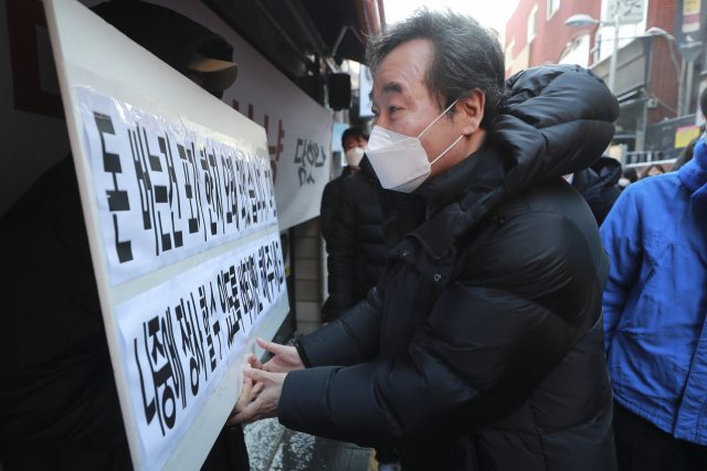 더불어민주당 이낙연 대표가 4일 오전 서울 용산구 이태원에서 열린 코로나19 피해 맞춤 지원을 위한 현장간담회 장소로 이동하며 지원 요청 내용이 담긴 피켓을 든 상인을 위로하고 있다. 연합뉴스