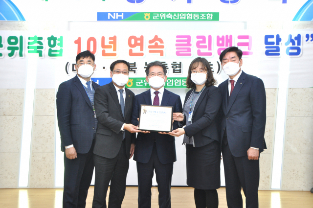 10년 연속 클린뱅크를 달성한 군위축협 김진열(가운데) 조합장이 임직원들과 함께 농협중앙회가 수여한 2020년 클린뱅크 인증서를 들어보이고 있다. 군위축협 제공