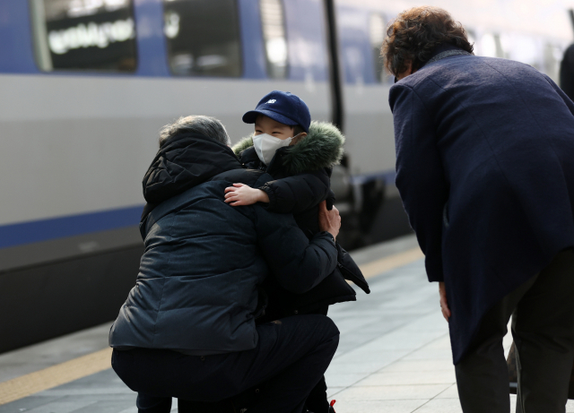 설날인 12일 오전 서울역에서 손주가 역귀성한 할아버지 품에 안기고 있다. 연합뉴스