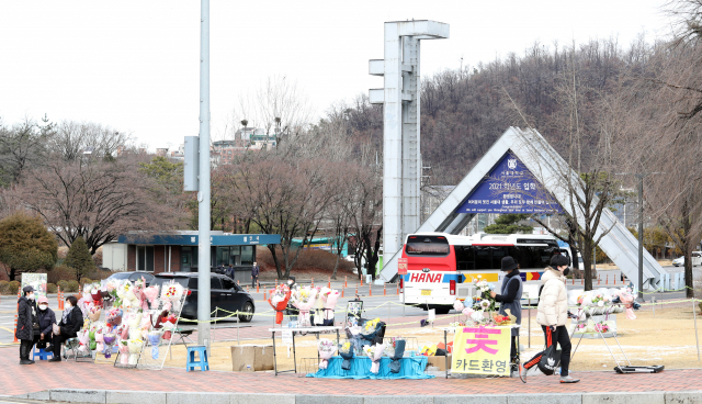 2일 관악구 서울대학교 정문에서 꽃을 파는 상인들과 사진사들이 신입생을 기다리고 있다. 코로나19로 비대면 입학식이라 학교를 찾는 신입생은 드물었다. 이날 서울대는 입학식을 별도의 행사 없이 유튜브로 진행했다. 연합뉴스