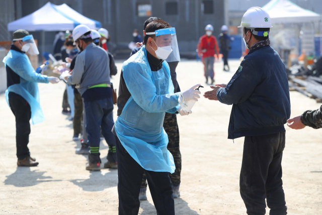 11일 오후 경북 경산의 한 건설 현장에 설치된 임시선별 진료소에서 외국인 근로자들이 신종 코로나바이러스 감염증(코로나19) 검사를 받기 위해 기다리고 있다. 앞서 경상북도는 사업장 집단감염을 선제적으로 차단하고자 행정명령을 내려 외국인 근로자를 5인 이상 고용한 사업주는 모든 외국인 근로자에 대해 오는 12일까지 코로나19 검사를 받도록 했다. 연합뉴스