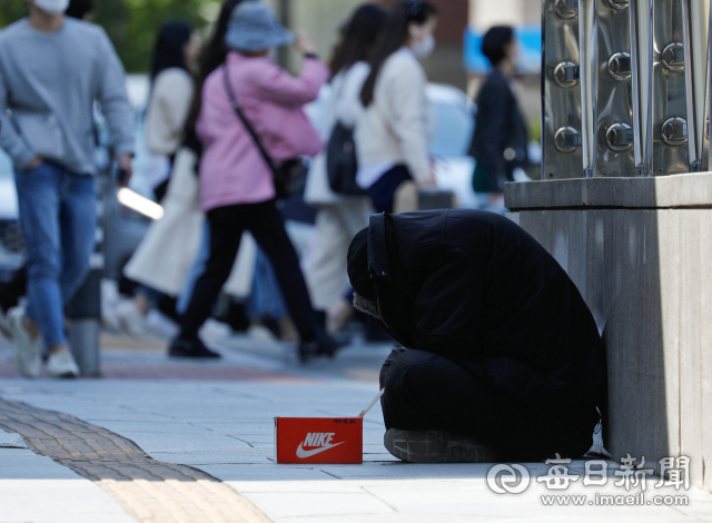 대구 중구 국채보상로 인도에서 한 노숙인이 꽃샘추위를 피해 몸을 웅크린 채 앉아 온정의 손길을 기다리고 있다. 매일신문 DB