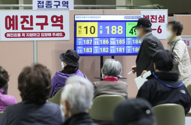 17일 오전 서울 동작구 사당종합체육관에 마련된 코로나19 접종센터에서 어르신들이 앉아 있다가 번호 순번에 따라 화이자 백신 접종 예진실로 들어가고 있다. 연합뉴스