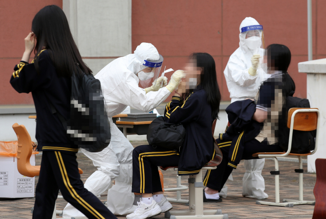 22일 오후 광주 북구 한 고등학교에 설치된 임시 선별진료소에서 학생들이 코로나19 검사를 받고 있다. 연합뉴스