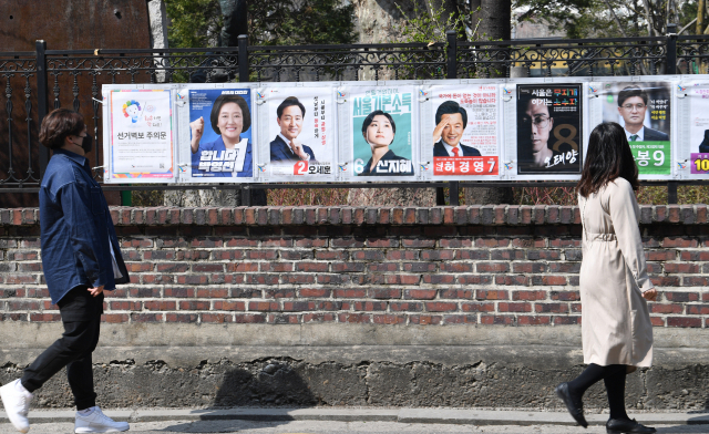 4·7 보궐선거 공식 선거운동 첫날인 25일 오후 시민들이 서울 종로구 예술가의 집 울타리에 부착된 선거 벽보를 살펴보고 있다. 연합뉴스