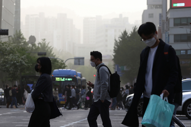 황사로 인해 서울지역에 미세먼지 경보가 발령된 7일 광화문 광장 인근에서 시민들이 퇴근길을 재촉하고 있다. 연합뉴스