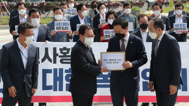 국민의힘 김기현 당 대표 권한대행 겸 원내대표(오른쪽 두 번째)가 14일 오전 서울 종로구 청와대 분수대 앞에서 유영민 대통령 비서실장에게 김부겸 총리 인준 강행 항의서한을 전달하고 있다. 연합뉴스