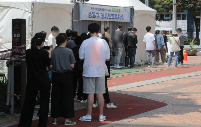 22일 오전 서울 성동구 임시선별진료소에서 시민들이 코로나19 검사를 받기위해 줄을 서고 있다. 중앙방역대책본부는 이날 0시 기준으로 코로나19 신규 확진자가 666명 늘어 누적 13만5천344명이라고 밝혔다. 연합뉴스