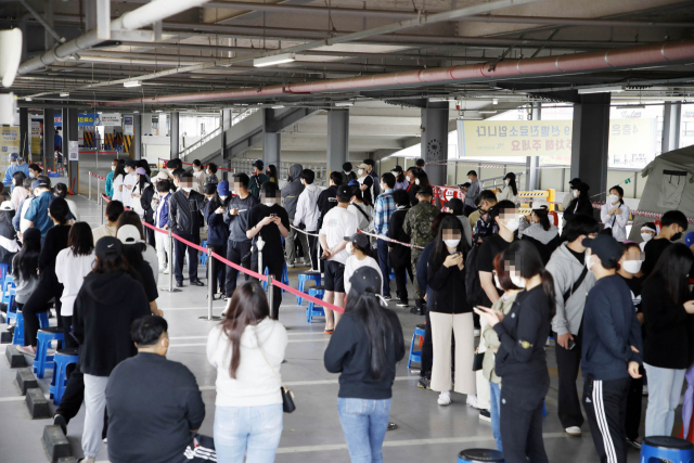 27일 오전 광주 북구선별진료소에 코로나19 검사 대기자가 늘어서 있다. 광주 지역 다중이용시설에 코로나19 확진자가 거쳐 간 후로 관내 선별진료소에 검사를 받으려는 시민들이 몰려들고 있다. 연합뉴스