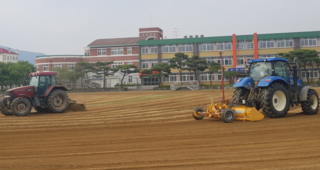 성주 초전중 총동창회와 초전면사무소가 트랙터와 균평기 등을 활용해 학교 운동장 제초 및 평탄작업을 하고 있다. 초전중 제공