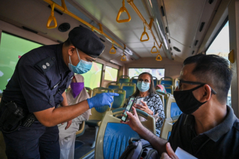 말레이시아가 1일부터 전국 봉쇄에 다시 들어간 가운데 쿠알라룸푸르에서 경찰관이 버스 승객의 여행 관련 문서를 확인하고 있다. AFP·연합뉴스