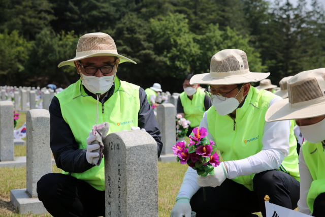 유찬형 농협중앙회 부회장(왼쪽)과 변대근 농협중앙회 홍보상무를 비롯한 범농협 홍보담당 직원들이 2일 국립서울현충원 26번 묘역에서 헌화봉사활동을 하고 있다. 농협중앙회 제공