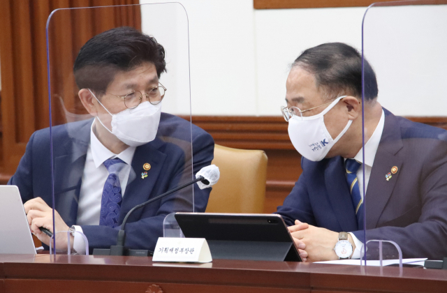 홍남기 부총리 겸 기획재정부 장관(오른쪽)과 노형욱 국토교통부 장관이 3일 정부서울청사에서 열린 국정현안점검조정회의에 참석해 대화하고 있다. 연합뉴스