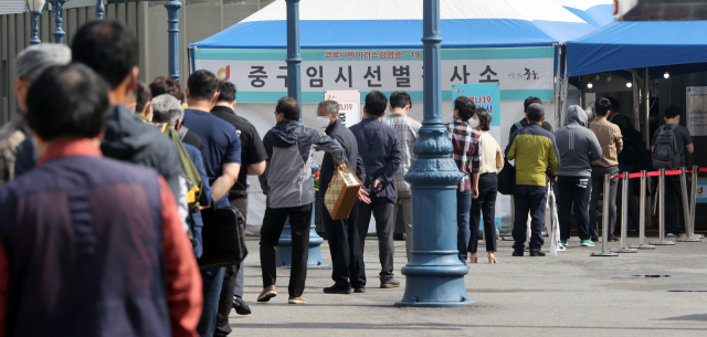 4일 서울역 광장에 설치된 중구 코로나19 임시선별검사소에서 검사를 받으려는 시민들이 줄을 서 대기하고 있다. 연합뉴스