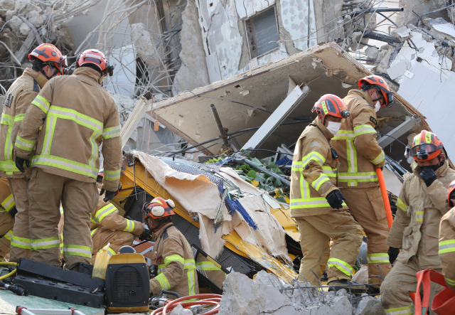 9일 오후 광주 동구 학동의 한 철거 작업 중이던 건물이 붕괴, 도로 위로 건물 잔해가 쏟아져 시내버스 등이 매몰됐다. 사진은 사고 현장에서 119 구조대원들이 구조 작업을 펼치는 모습. 연합뉴스