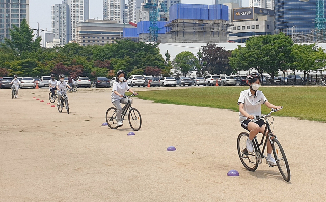 기후 위기 시대 속에 환경교육의 중요성도 커지고 있다. 다만 일방적으로 교육 내용을 전달할 게 아니라 함께 고민하고 실천하는 방법을 고민해야 한다. 학교 현장에선 그런 움직임이 조금씩 보이고 있다. 대구여고 1학년 학생들이 체육 수업 중 자전거를 타는 모습. 대구시교육청 제공