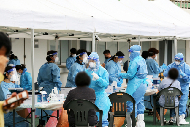 23일 오후 경북 포항종합운동장에 마련된 임시 선별진료소에서 포항시민이 신종 코로나바이러스 감염증(코로나19) 검사를 받고 있다. 포항시는 최근 포항세명기독병원에서 코로나19 확진자가 무더기로 발생함에 따라 이달 1일부터 병원에 다녀간 환자와 보호자 등에게 검사를 받도록 안내했다. 연합뉴스